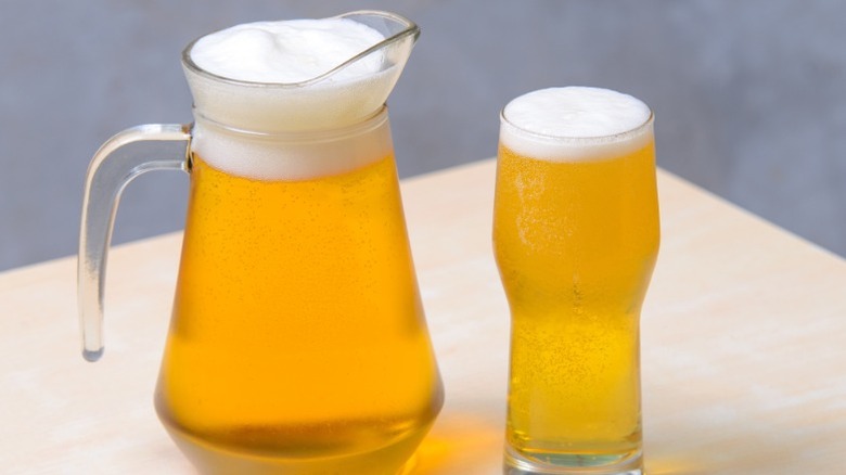 A pitcher of beer and a glass of beer on a table