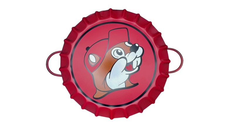 A red metal serving tray shaped like a bottle cap with the Buc-ee's logo on it against a white background