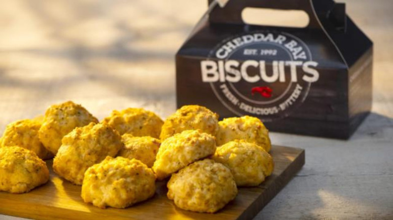 A wood board with Red Lobster Cheddar Bay Biscuits with the biscuit package in the background