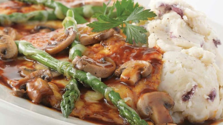 Chicken Madeira from The Cheesecake Factory served with mashed potatoes and topped with asparagus