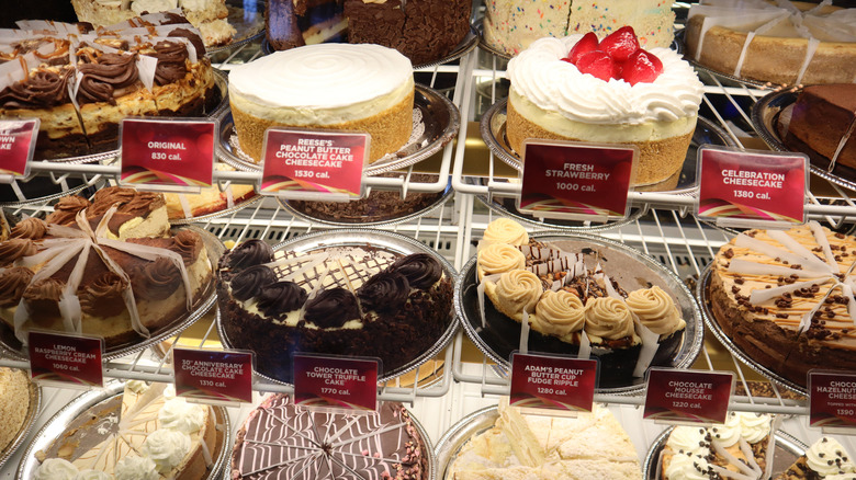 Several cheesecakes from The Cheesecake Factory lined up in a display case