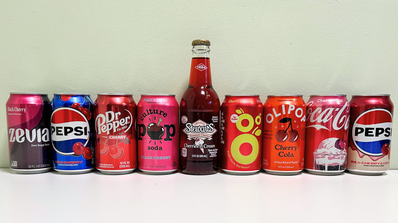 Several cans of cherry-flavored sodas arranged together in a line