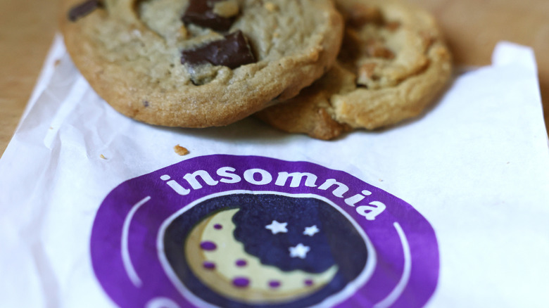 Two chocolate chip cookies on an Insomnia cookie napkin