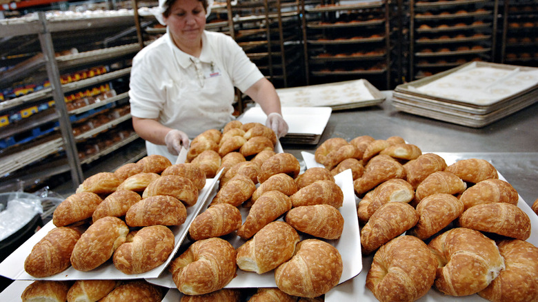 Costco bakery worker with trays of bread