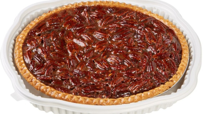 a whole pecan pie in a white container