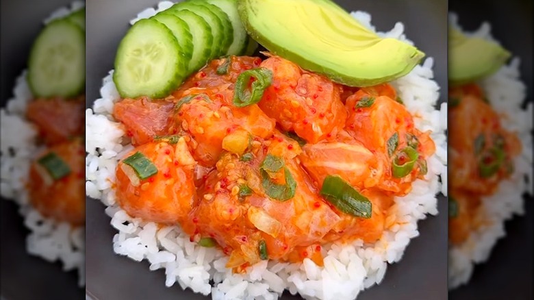 salmon poke bowl with rice, cucumbers, and avocado