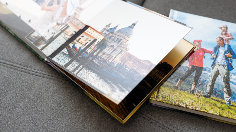Two photo books show pictures of a family in different locations.