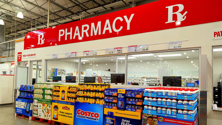 A photograph of a Costco in-store pharmacy, "pharmacy" is written on a sign in large letters.