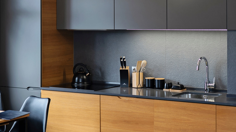 A modern kitchen with gray and brown wood cabinets