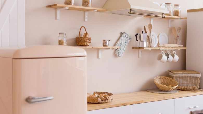 A retro kitchen with pinkish-beige walls and refrigerator