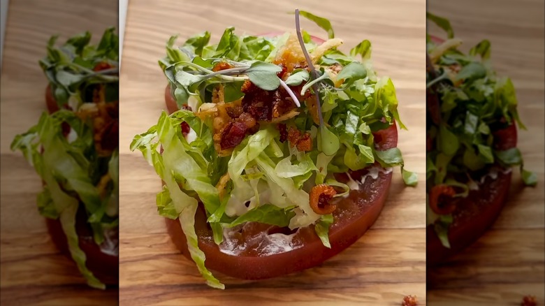 BLT-style tomato on a wood serving board