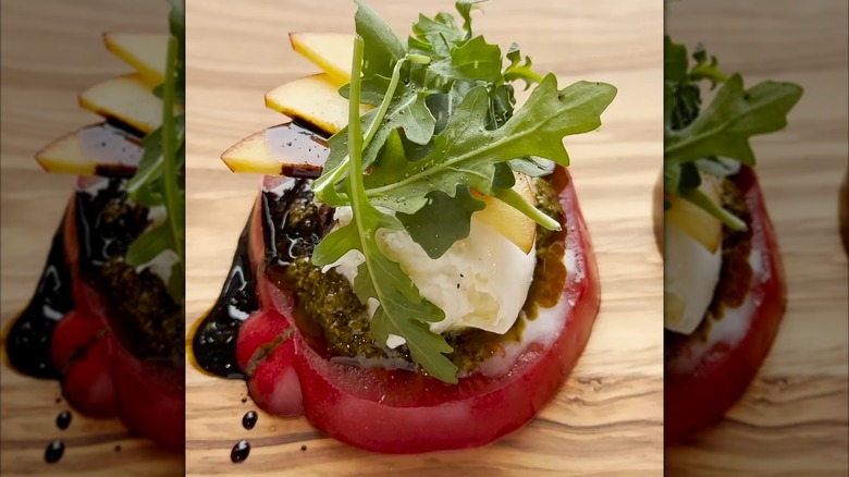 Caprese-style tomato on a wood serving board with