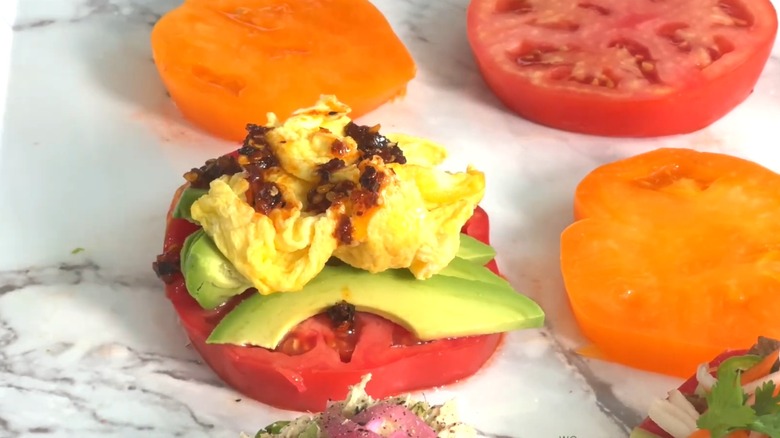 Chili egg scramble on a marble-like background with other tomato slices