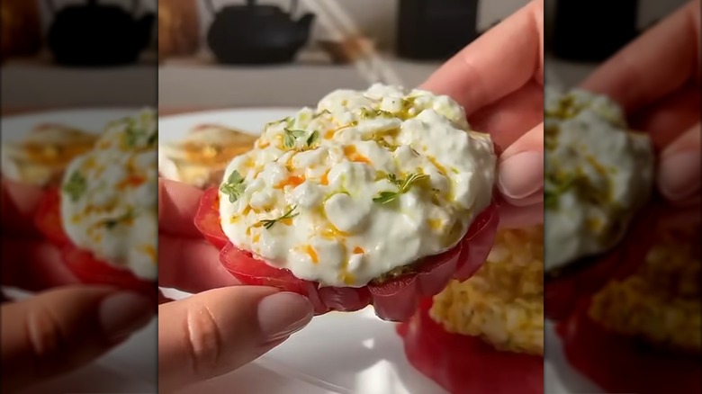 Cottage cheese-style tomato held over plate