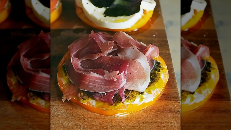 Deli sandwich-style tomato on a wood serving board