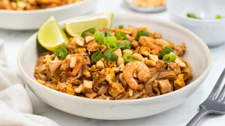 Shrimp pad thai with lime wedges