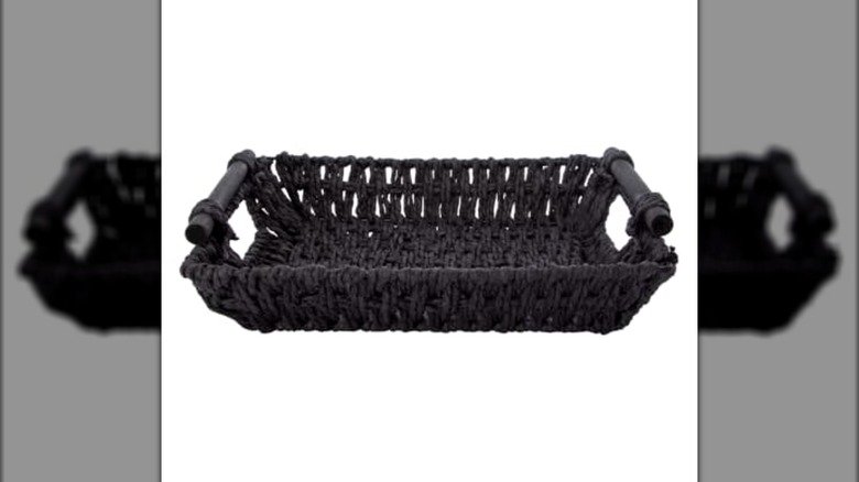 A woven black basket with black handles