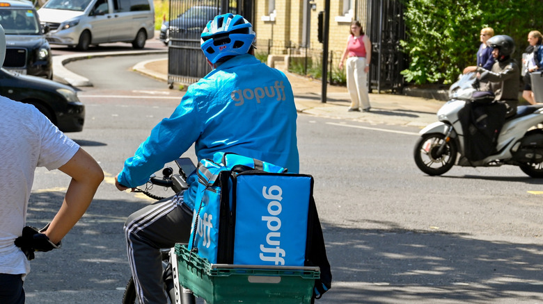 A photo of a Gopuff biker with a blue delivery bag