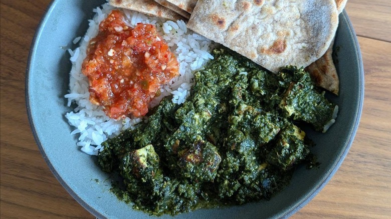 Cooked lambsquarters on the side of saag paneer and homemade roti