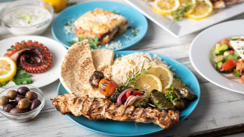 An assortment of popular Greek foods arranged on different plates