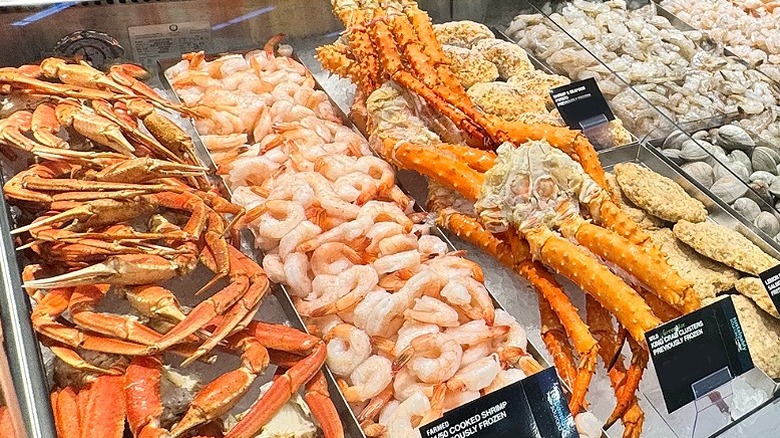 A seafood counter with shrimp, crab legs, and various other seafood items