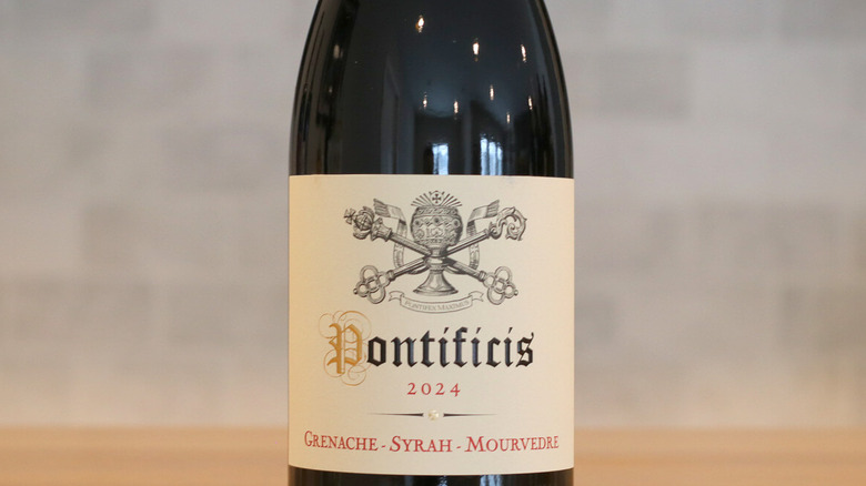 Close up of a Pontificis GSM bottle on table with a blurry gray background