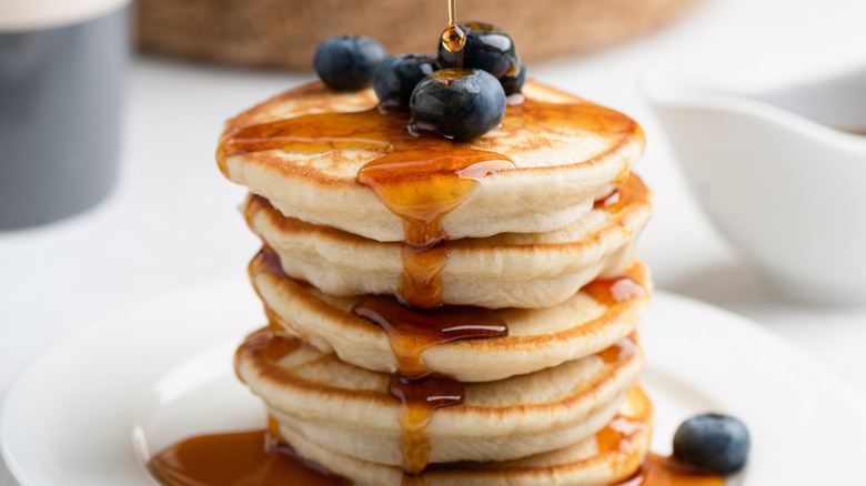 A stack of small protein pancakes, topped with berries