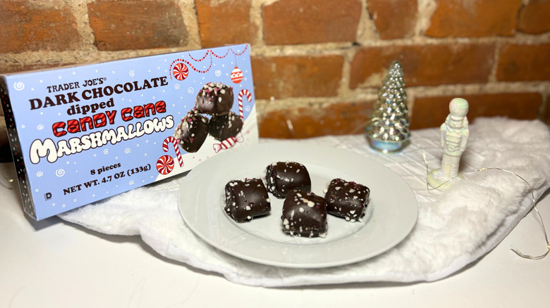 A plate of marshmallows next to a box against a brick background