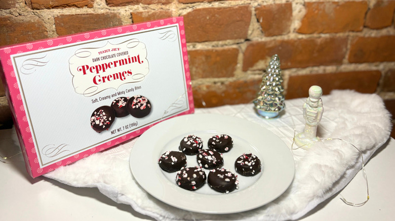 A plate of cremes next to a box against a brick background