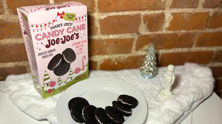 A plate of cookies next to a box against a brick background