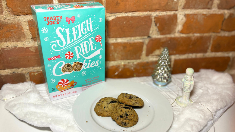 A plate of cookies next to a box against a brick background