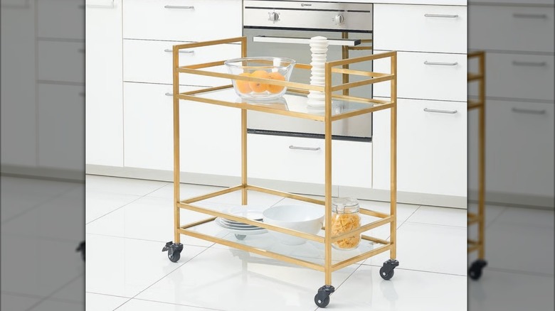 bronze cart with wheels in a very white kitchen