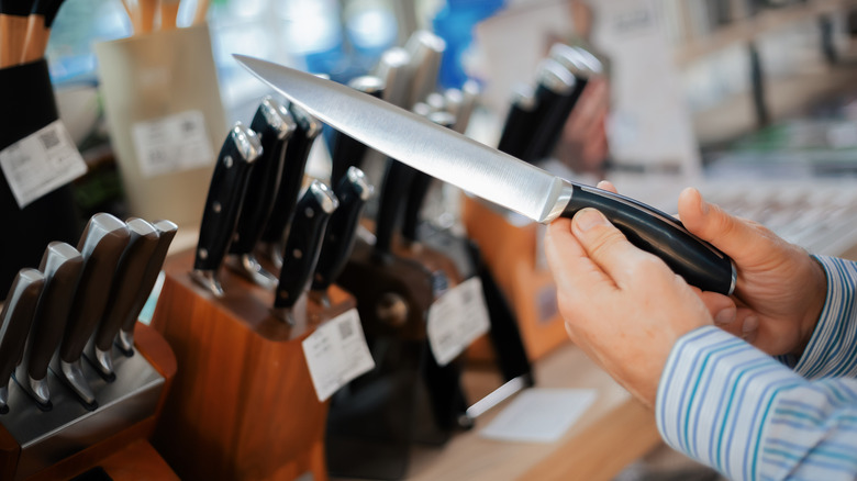 Man shopping for knife set at store