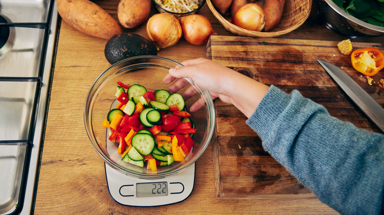 Chopped veggies in a bowl being measured on food scale