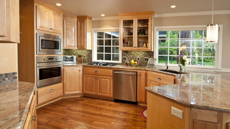 A '90s-style kitchen with light brown wood cabinets