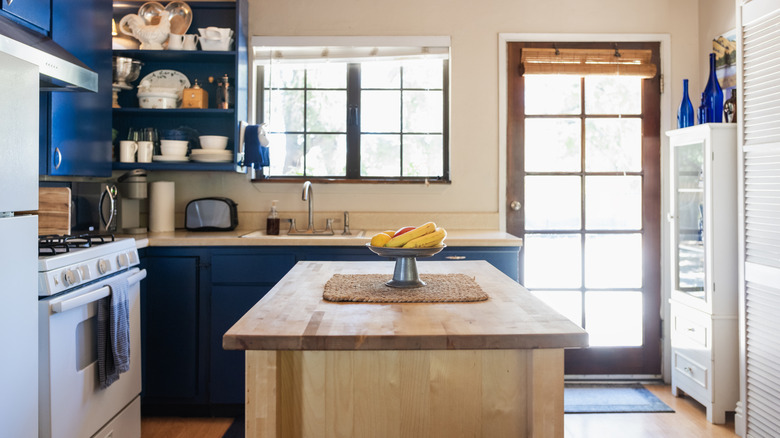 Kitchen with wood island and blue cabinetry