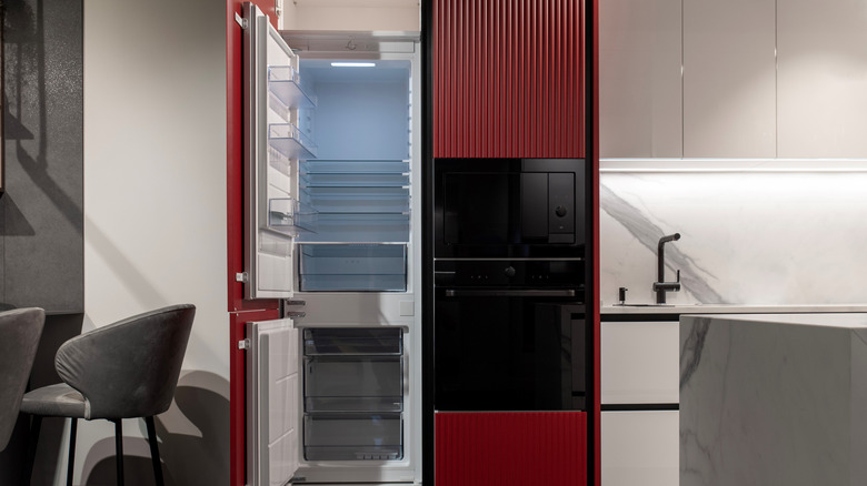 Built-in microwave, oven, and refrigerator in a red accent wall