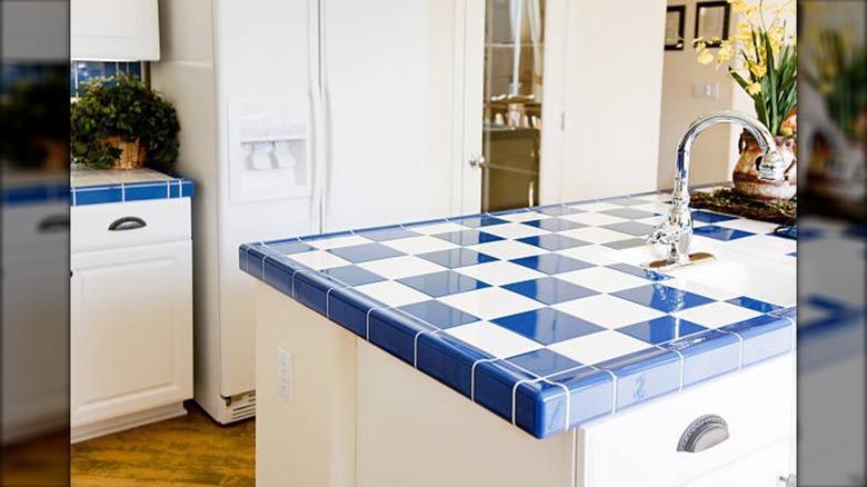 Blue and white checkered tile countertops in white kitchen