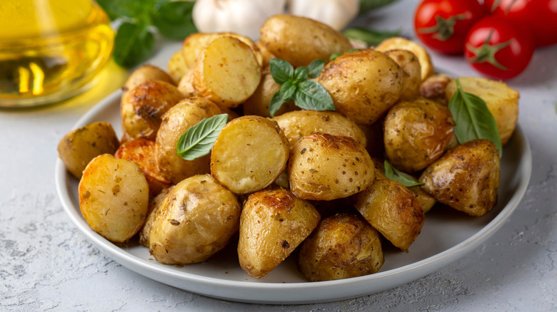 A plate of freshly roasted potatoes garnished with fresh herbs
