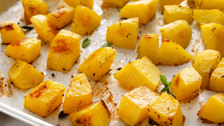 Close up of seasoned and oiled potato slices on a baking pan