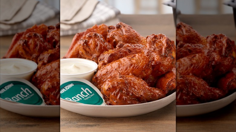 Close up of buffalo chicken wings from Papa Johns with a ramekin of ranch dressing