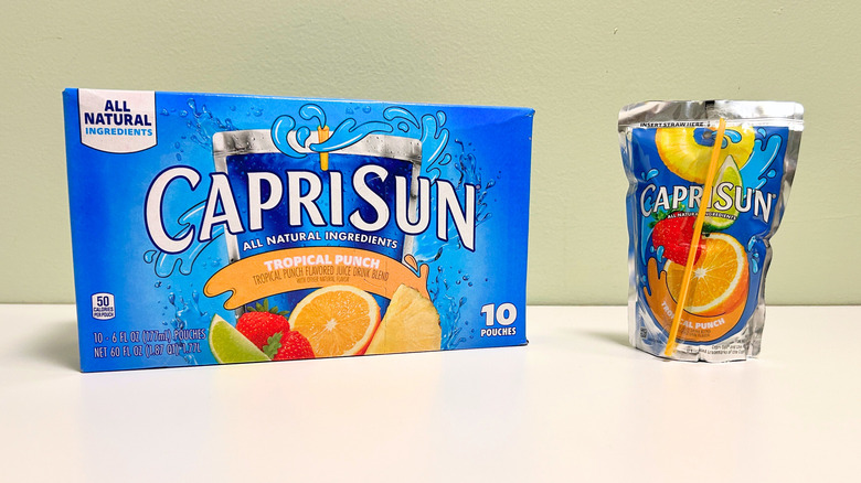 A box of Capri Sun Tropical Punch next to a pouch of tropical punch