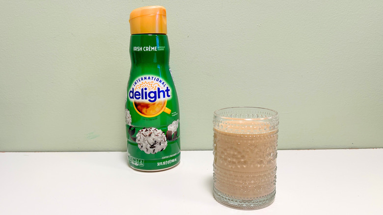 A cup of coffee next to a bottle of International Delight Irish Creme Coffee Creamer