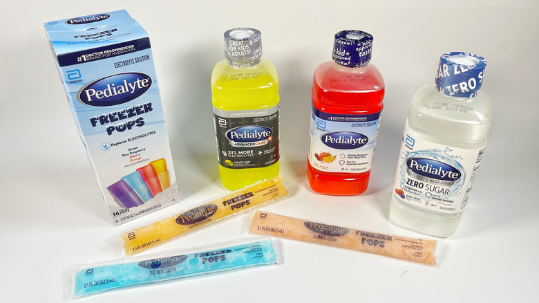 Several Pedialyte bottles and freezer pops on a white background