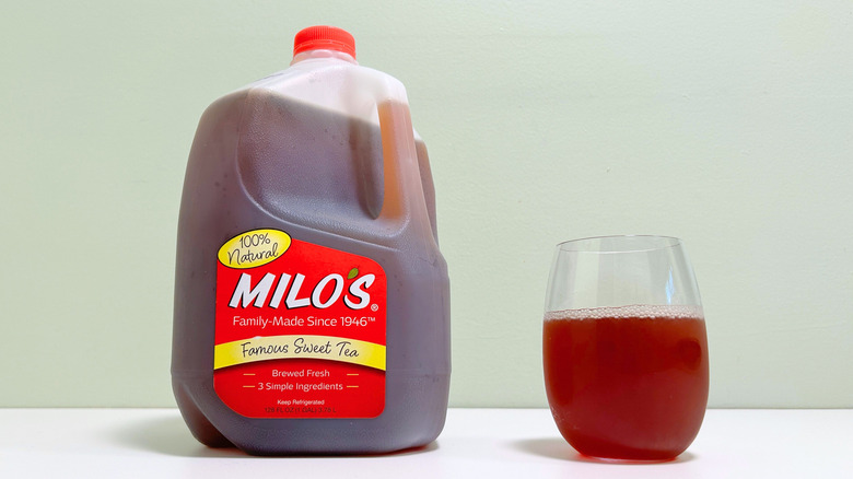 A jug of Milo's Famous Sweet Tea next to a glass of sweet tea