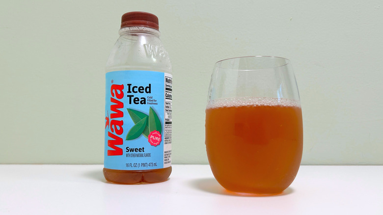 A bottle of Wawa Sweet Iced Tea next to a glass of sweet tea