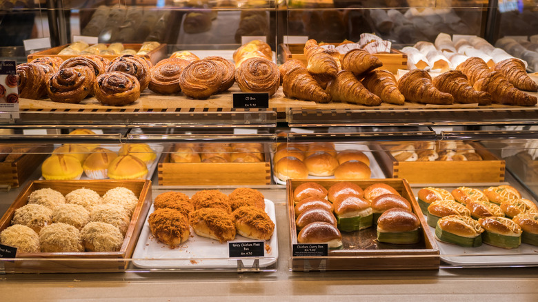 Various baked goods lined up inside a display case at a bakery