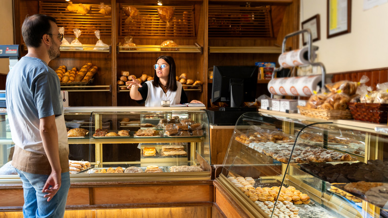 An employee talking to a customer at a bakery