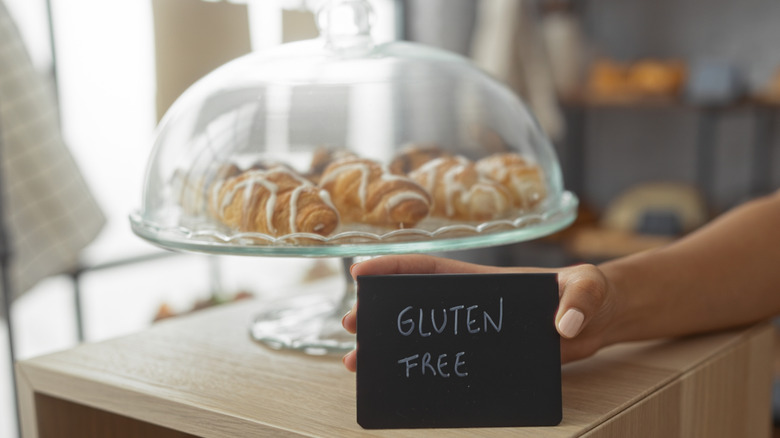 Baked goods on a stand with a gluten-free sign in front of them