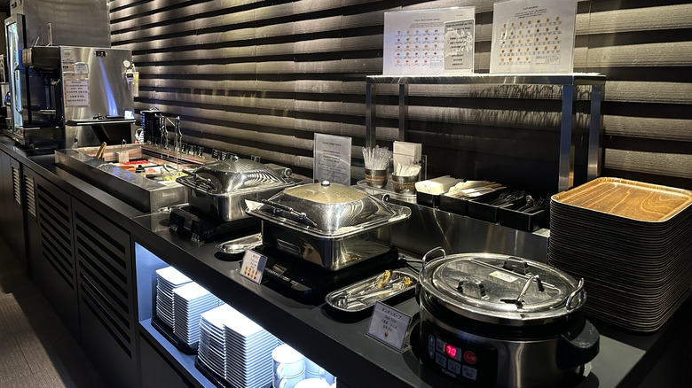 A buffet set-up, showing various hot plates, dishes, and utensils